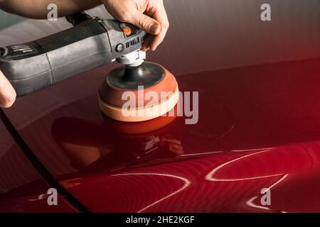 Polieren der Karosserie eines roten Autos Stockfoto