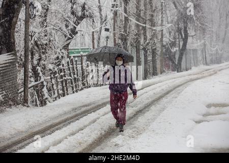 Srinagar, indisch kontrolliertes Kaschmir. 8th Januar 2022. Ein Mann geht inmitten des Schneefalls in der Stadt Srinagar, der Sommerhauptstadt des von Indien kontrollierten Kaschmir, am 8. Januar 2022. Quelle: Javed Dar/Xinhua/Alamy Live News Stockfoto