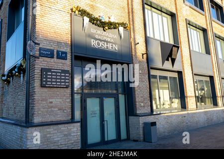 Ukraine, Kiew - 7. Januar 2022: Roshen Chocolate Factory. Haupteingang zum Gebäude und Schild-Logo. Süßwarenfabrik, Firmenzeichen Roshen. Stockfoto