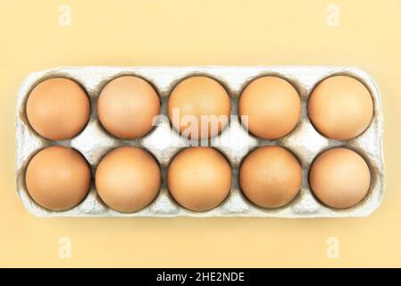 Eier in einem Papiertablett auf beigefarbenem Hintergrund. Stockfoto
