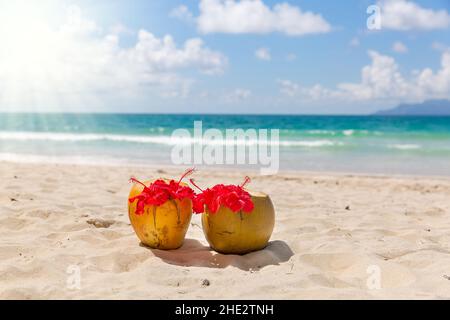 Zwei Kokosnuss Cocktails am weißen Sandstrand neben sauberen Meer blaues Wasser. Urlaub und Reisen-Konzept Stockfoto