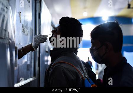 Guwahati, Indien. 08th Januar 2022. Ein Mitarbeiter des Gesundheitswesens nimmt am Samstag, den 8. Januar, im Bahnhof Guwahati in Guwahati, Assam, Indien, eine Abstrichprobe für COVID-19-Tests ab. 2022. Die täglichen Fälle von Covid-19 stiegen innerhalb von 24 Stunden um 21%, da Indien mehr als hunderttausend frische Infektionen verzeichnete. Quelle: David Talukdar/Alamy Live News Stockfoto