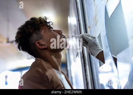 Guwahati, Indien. 08th Januar 2022. Ein Mitarbeiter des Gesundheitswesens nimmt am Samstag, den 8. Januar, im Bahnhof Guwahati in Guwahati, Assam, Indien, eine Abstrichprobe für COVID-19-Tests ab. 2022. Die täglichen Fälle von Covid-19 stiegen innerhalb von 24 Stunden um 21%, da Indien mehr als hunderttausend frische Infektionen verzeichnete. Quelle: David Talukdar/Alamy Live News Stockfoto