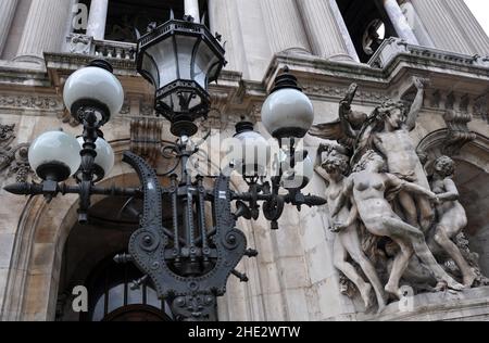 Vor dem Pariser Opernhaus Palais Garnier steht neben der Kopie der Skulptur La Danse von Jean-Baptiste Carpeaux ein reich verzierter Lampenpfosten. Stockfoto