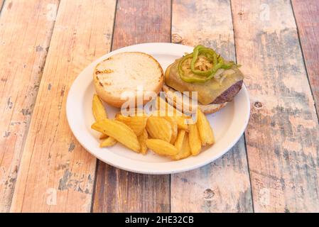 Beef Burger mit gewürfelten Pommes frites, gebratenen grünen Paprika, gebratenen Zwiebeln und Toast Stockfoto
