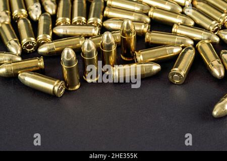 Viele Messingpistolen Kugeln auf schwarzem Tisch Nahaufnahme, Platz für Text unteren Teil Stockfoto