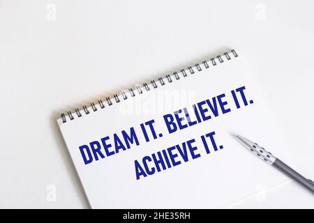 Traum. Glauben Sie es. Erreichen Sie dies. Inspirierendes Motivationszitat auf Notizblock und weißem Hintergrund. Stockfoto