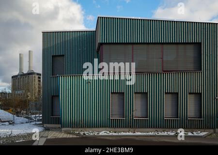 Ein grünes Schulgebäude auf dem Campus Rudolf Steiner Waldorfschule in München. Die Fenster ard schlossen sich mit Metalljalousien. Stockfoto