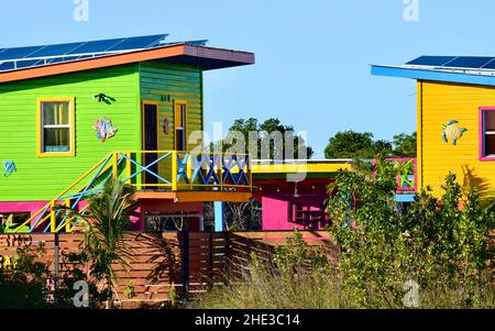 Einige farbenfrohe Gebäude mit Sonnenkollektoren auf der Straße zum Secret Beach in San Pedro, Belize. Stockfoto