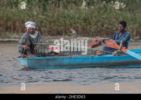 Männer Köder Haken und Fischernetz in einem kleinen Boot in See Nasser, Teil des Nils in Ägypten. Stockfoto