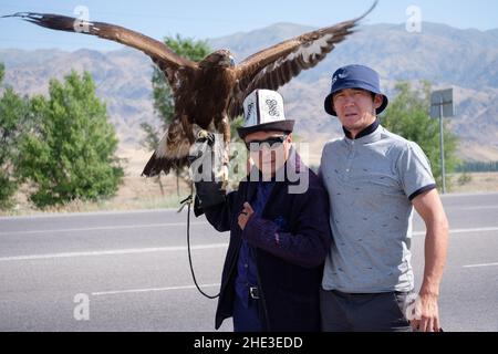 Kirgisischer Adlerjäger posiert mit Steinadler Stockfoto