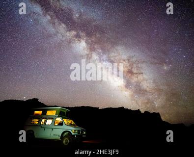 Milchstraße über dem Wohnmobil mit angeleuchtetem Licht, während der Bootsanlegeplatz hinter der Reef Road im San Rafael Reef Area, Utah, zeltet. Stockfoto