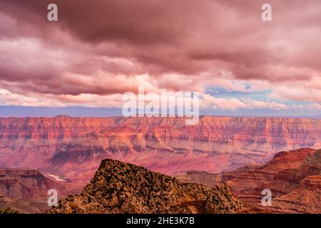Grand Canyon with Colorado River in distance clouds overhead reflecting sunset light bringing out red tones of the Canyon walls view from Cape Royal Stockfoto