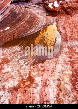 Ein seltenes Vorkommen, Schnee auf rot und weiß abgestreiften Felsen, der sich in einem Wasserbecken im White Pocket Area des Vermilion Cliffs National Monument, AZ, widerspiegelt. Stockfoto