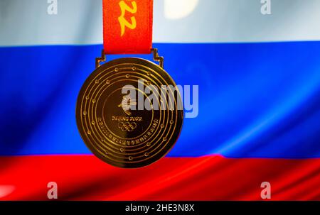 5. Januar 2021, Peking China. Goldmedaille der XXIV. Olympischen Winterspiele vor dem Hintergrund der russischen Flagge. Stockfoto