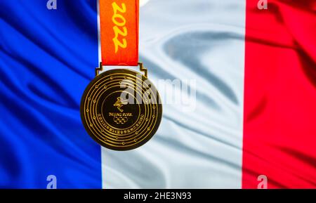 5. Januar 2021, Peking China. Goldmedaille der XXIV. Olympischen Winterspiele vor dem Hintergrund der Flagge Frankreichs. Stockfoto