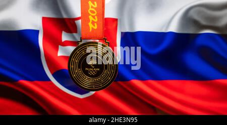 5. Januar 2021, Peking China. Goldmedaille der XXIV. Olympischen Winterspiele vor dem Hintergrund der Flagge der Slowakei. Stockfoto