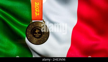 5. Januar 2021, Peking China. Goldmedaille der XXIV. Olympischen Winterspiele vor dem Hintergrund der italienischen Flagge. Stockfoto