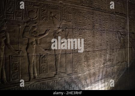 Eine Tempelmauer im Philae-Komplex in Ägypten. Die Steinwände sind mit Inschriften, Hieroglyphen und Reliefskulpturen bedeckt. Stockfoto
