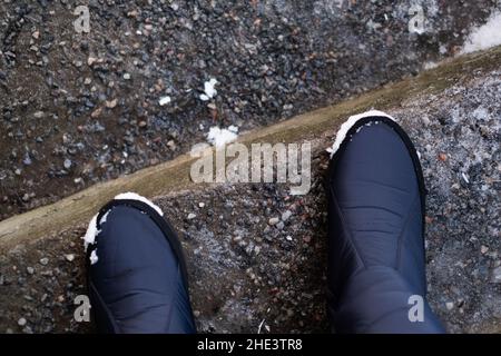 Stehen auf vereisten Treppen mit Granitschutt. Im Winter wurden Granitsiebe auf rutschigen Treppenstufen im Freien verteilt. Rutschfeste Wartung. Stockfoto