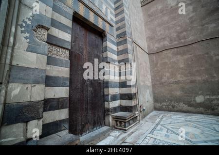 Eine kunstvoll verzierte Tür innerhalb der Moschee-Madrasa von Sultan Hassan in Kairo, Ägypten. Stockfoto