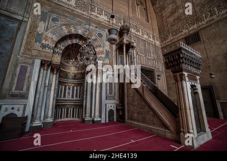 Die komplizierten Marmor-Qibla, Minbar und Mihrab von einem der Iwans innerhalb der Moschee madrasa von Sultan Hassan in Kairo, Ägypten. Ein historisches Wahrzeichen. Stockfoto