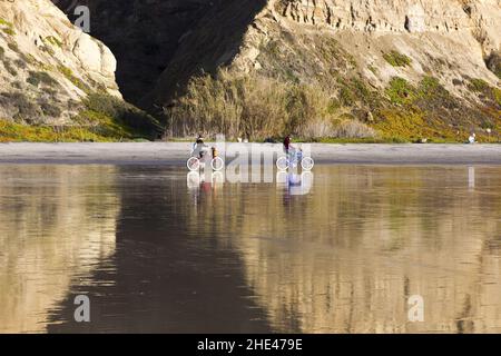 Fahrradfahren am Black's Beach. Radfahrer Menschen Radfahren auf Sand im Torrey Pines State Preserve an einem sonnigen Wintertag in San Diego, Kalifornien, USA Stockfoto