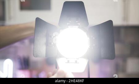 Nahaufnahme der Hände, die die Klingen des Spurlichts berühren. Männliche Hände machen Spotlicht anstelle von diffusem Licht, elektrische Beleuchtung des Raumes. Stockfoto