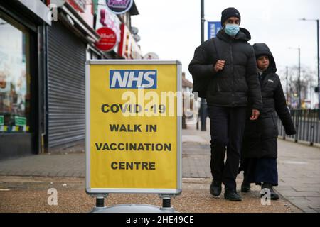 London, Großbritannien. 8th Januar 2022. Die Menschen sahen an einem Covid -19-Impfschild vorbeilaufen. (Bild: © Dinendra Haria/SOPA Images via ZUMA Press Wire) Stockfoto