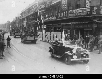 Zweiter Chinesisch-Japanischer Krieg, 1937-1945. Nach ihrem Sieg gegen die Truppen der chinesischen Nationalen Revolutionären Armee in der Stadt am 1937. Dezember patrouillieren ein japanischer Beamter der Sondermarine Landing Force, gefolgt von drei mittleren Panzern des Typs 89 und einer Carden Loyd Tankette in einer von Japan bewohnten Straße in Shanghai. Stockfoto