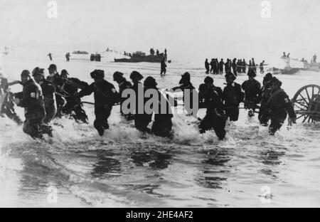 Zweiter Chinesisch-Japanischer Krieg, 1937-1945. Die japanischen Truppen der Sondermarinelandetruppen entladen sich von Landungsbargen und waten mit ihren Artilleriebögen im Schlepptau an Land, um die Küstenstadt Tsingtao (Qingdao) zu erobern, 14th. Januar 1938. Stockfoto