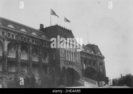 Zweiter Chinesisch-Japanischer Krieg, 1937-1945. Das Rathaus von Tsingtao (Qingdao), das unter der Besatzung der kaiserlichen japanischen Marine steht, fliegt um 1938 von der Dachterrasse aus, die Flagge eines hinteren Admirals und das Flottenschild. Stockfoto