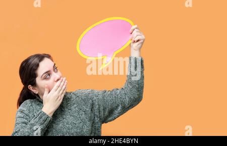 Überrascht kaukasische Frau mit Sprechballon, isoliert auf orangefarbenem Hintergrund. Stockfoto