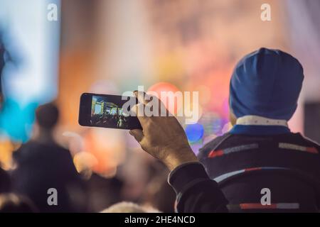 Verwenden Sie Advanced mobile Recording, Spaß Konzerte und schöne Beleuchtung, ehrliches Bild der Masse an Rock Konzert, Nahaufnahme von der Aufnahme von Video mit Smartphone Stockfoto