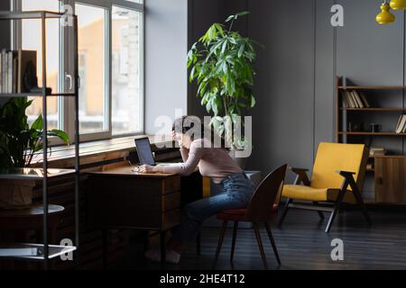 Arbeitsermüdung. Junge müde überarbeitete Freiberuflerin fühlt sich müde, erschöpft und unproduktiv Stockfoto