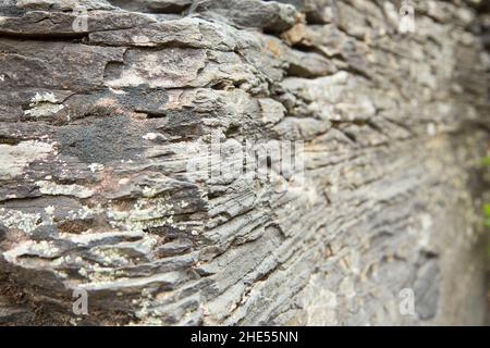 Schichten und Risse in der Steinwand, Seitenansicht Stockfoto