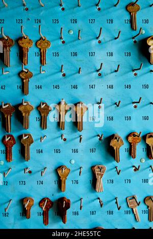 Alte leere Schlüssel auf blauem Panel mit Haken 1, Vorderansicht Stockfoto