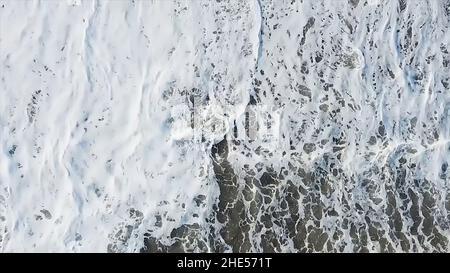Blick von oben auf die Meereswellen. Meereswellen und Schaum von einem Kreuzschiff. Textur der schönen Welle im Ozean. Meerwasser glatte Oberfläche, Ozean Reflexion Sonne. Stockfoto