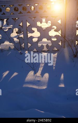 Zaun mit kasachischen Mustern im Winter mit Licht, das von der Sonne durchkommt Stockfoto