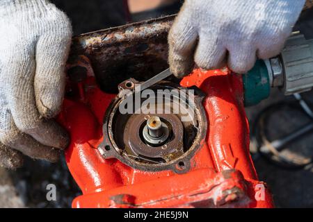 Mann Arbeiter Reparatur Motor mit seinen Händen, Nahaufnahme Stockfoto