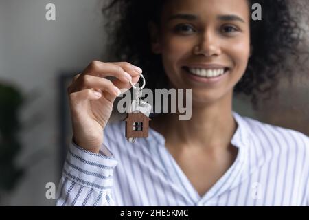 Lächelnde junge afroamerikanische Frau, die Schlüssel zeigt. Stockfoto