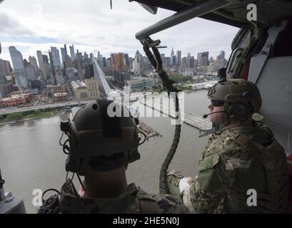 Segler fliegen im Rahmen der Fleet Week New York 2017 mit einem Hubschrauber vom Typ MH-60s Sea Hawk an der Skyline von New York vorbei. (34148334304). Stockfoto