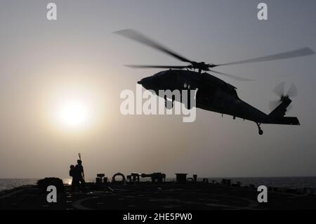 Seeleute bereiten sich darauf vor, ein Frachtnetz mit leeren Holzpaletten an einem Hubschrauber der MH-60s Sea Hawk (5957540141) zu befestigen. Stockfoto