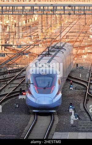 YANTAI, CHINA - 9. JANUAR 2022 - Ein Fuxing-HOCHGESCHWINDIGKEITSZUG verlässt den Yantai-Bahnhof in Yantai, Ostchinas Provinz Shandong, 9. Januar 2022. Chinas Stockfoto