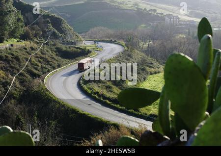 sizilianische Landschaft mit Kaktus Kaktus Kaktus Kaktus Birne und Berg kurvige Straße und LKW Stockfoto