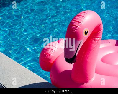 Nahaufnahme des pinken aufblasbaren Rings, Flamingo im Schwimmbad mit Kopierraum. Flamingo Schwimmring für Sommerstrand. Stockfoto