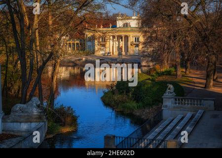 Spätherbst im Royal Lazienki Park in der Stadt Warschau, Polen. See und Palast auf der Insel bei Sonnenaufgang, neoklassische Sommerresidenz von König Stanisław Stockfoto