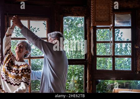 Ältere Menschen glücklich Lebensfreude Aktivität mit zwei älteren Mann und Frau tanzen aufgeregt zu Hause für Liebe und Beziehung - Ältere Paare haben Spaß an th Stockfoto