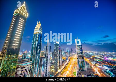 Wolkenkratzer in der Innenstadt von Dubai entlang der Sheikh Zayed Road, Luftaufnahme bei Nacht Stockfoto