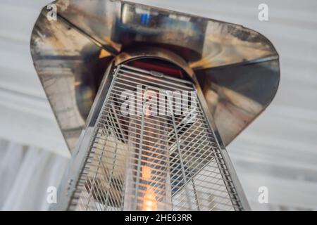 Heizlampe heizofen zwischen den Tischen eines offenen Cafe platziert Stockfoto